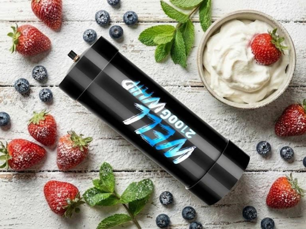 Black well 2100 whip canister on white wood background, surrounded by strawberries, blueberries, mint leaves, and a bowl of whipped cream. Fresh and inviting.