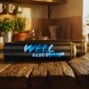 Two black canisters marked "WELL 640G WHIP" sit on a rustic wooden table in a cozy kitchen with plants and warm sunlight, creating a peaceful atmosphere.
